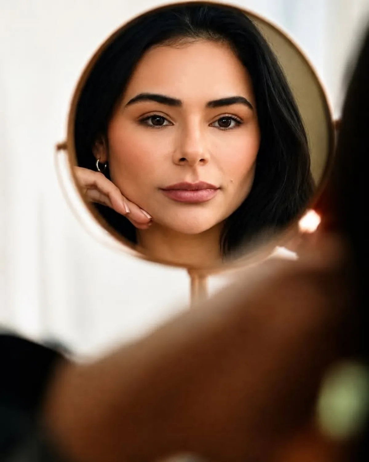 Dra. Priscila Sousa refletida em espelho durante avaliação estética facial